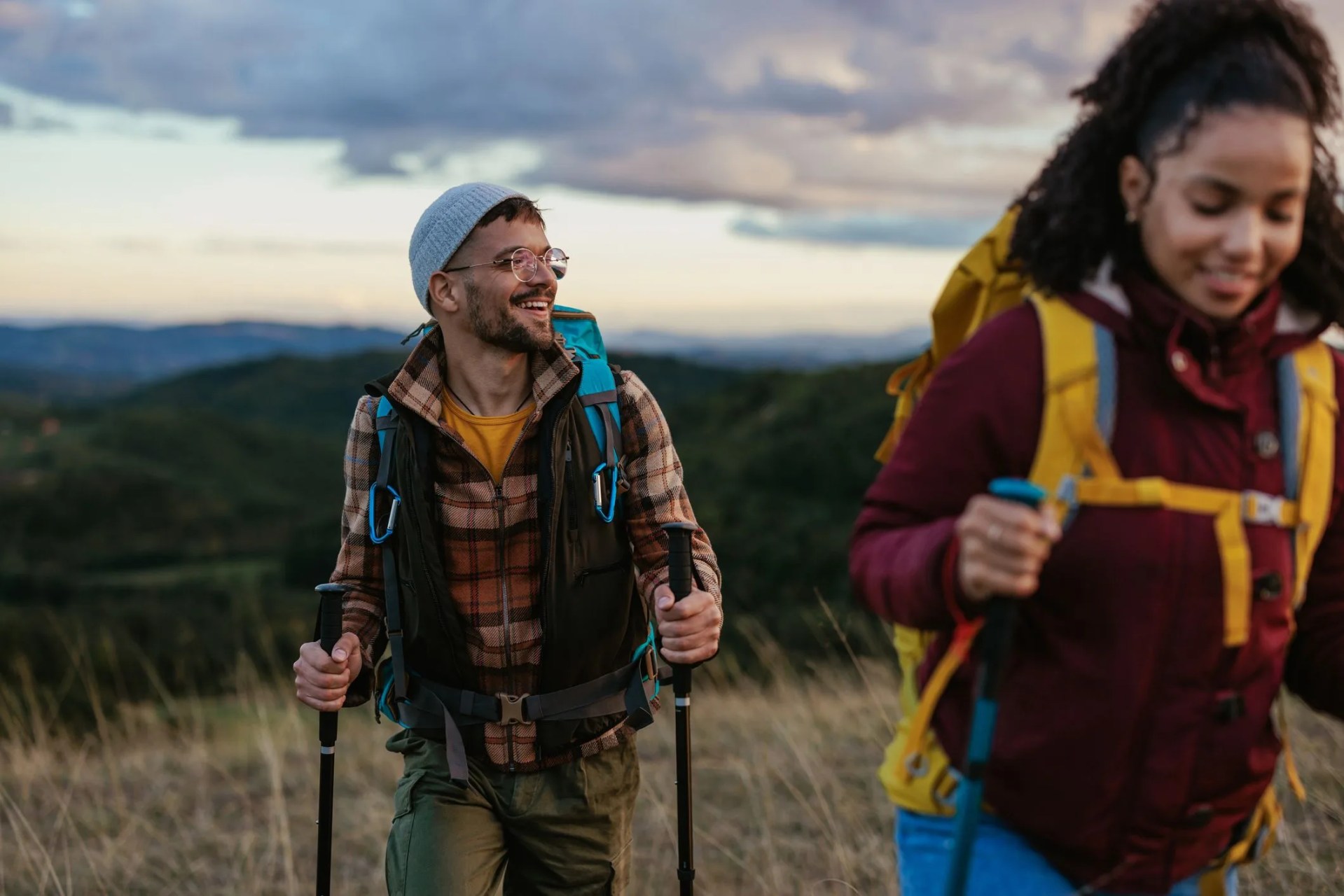 a young cheerful mixed race couple is hiking over the weekend in the mountains they are relaxing in nature after a busy week
