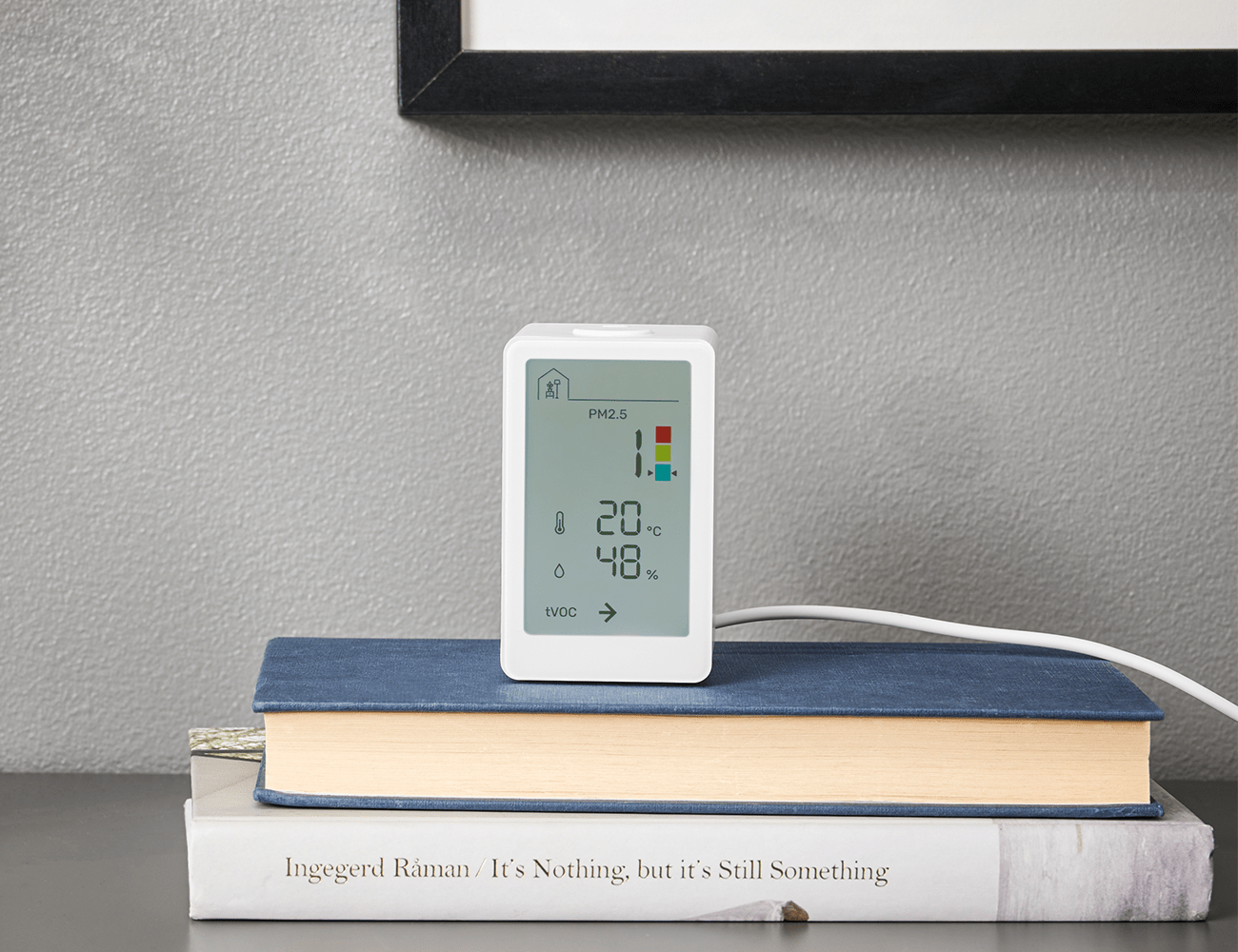a white ikea vindstyka device sitting ontop of some books
