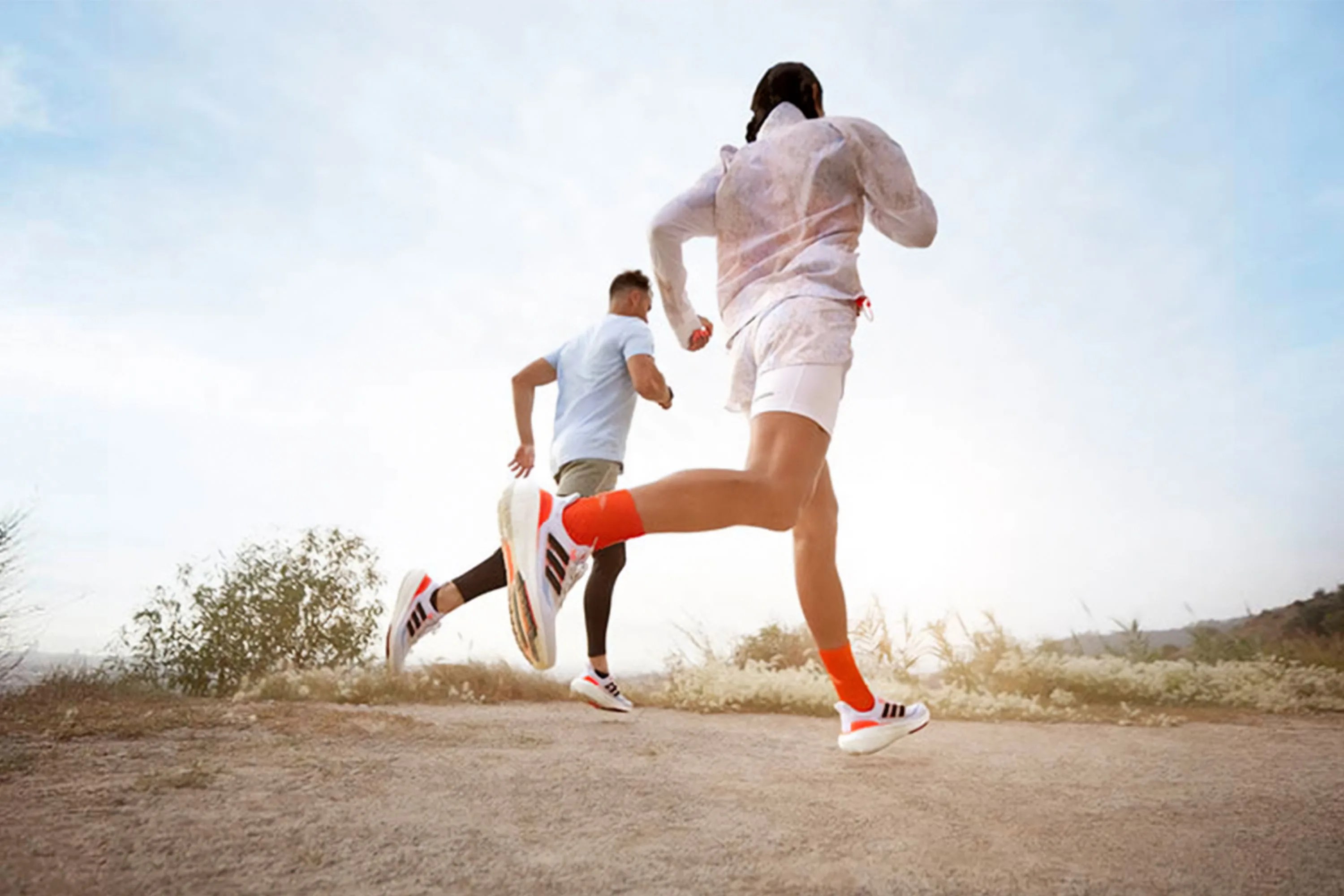 two people running on a dirt trail