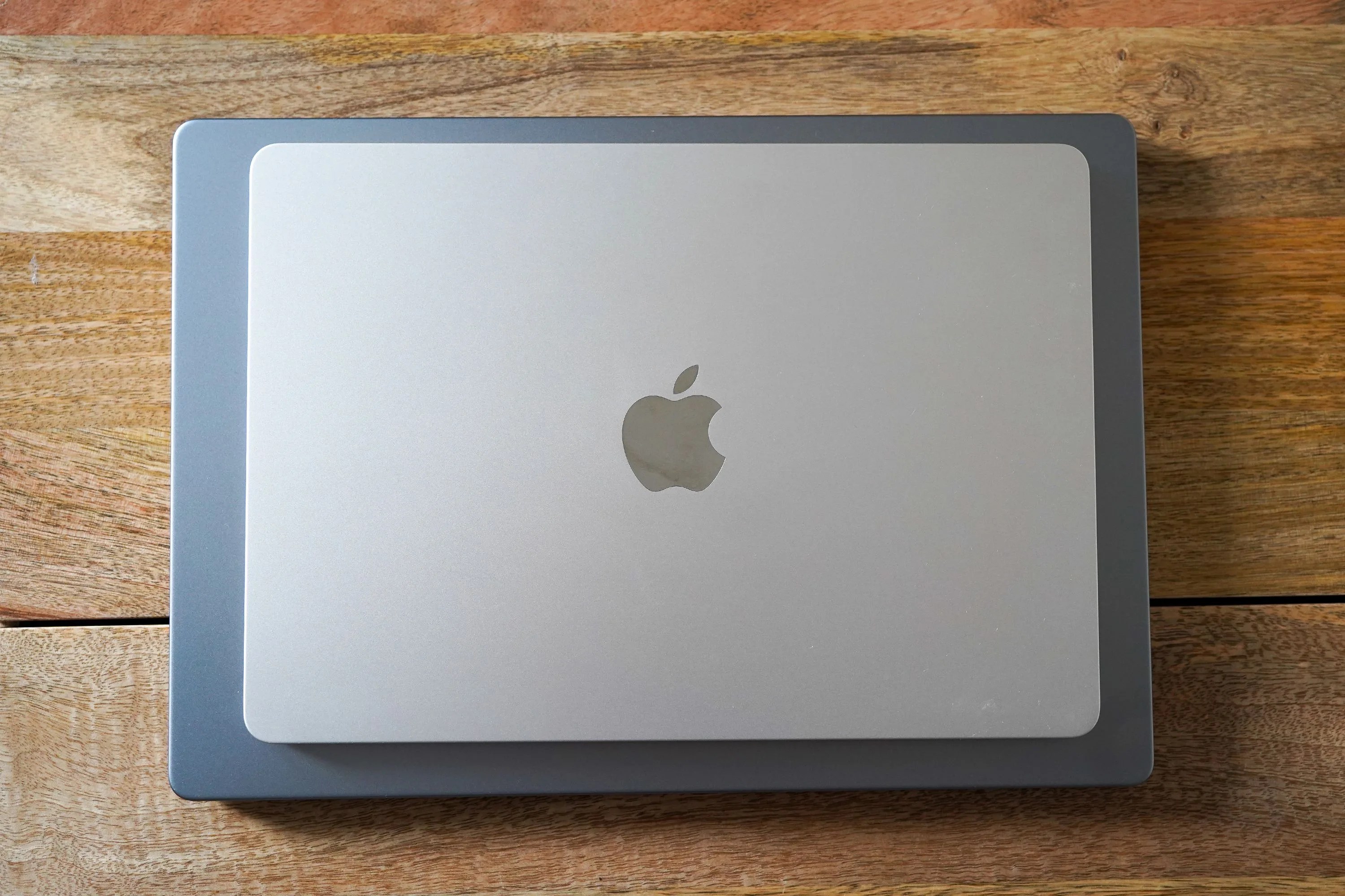2 macbooks sitting on top of each other on a table