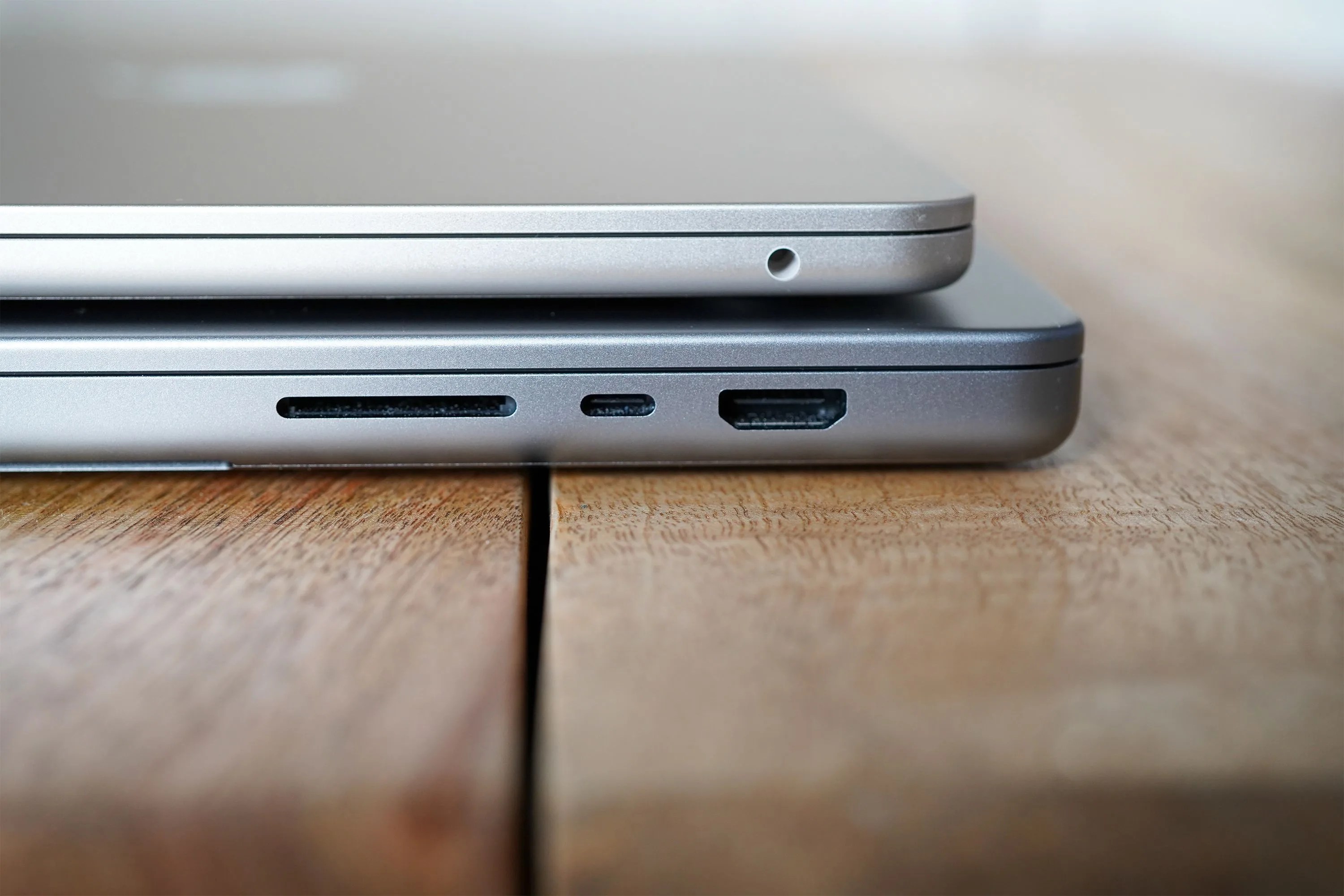 2 macbooks stacked on top of each other sitting on a table