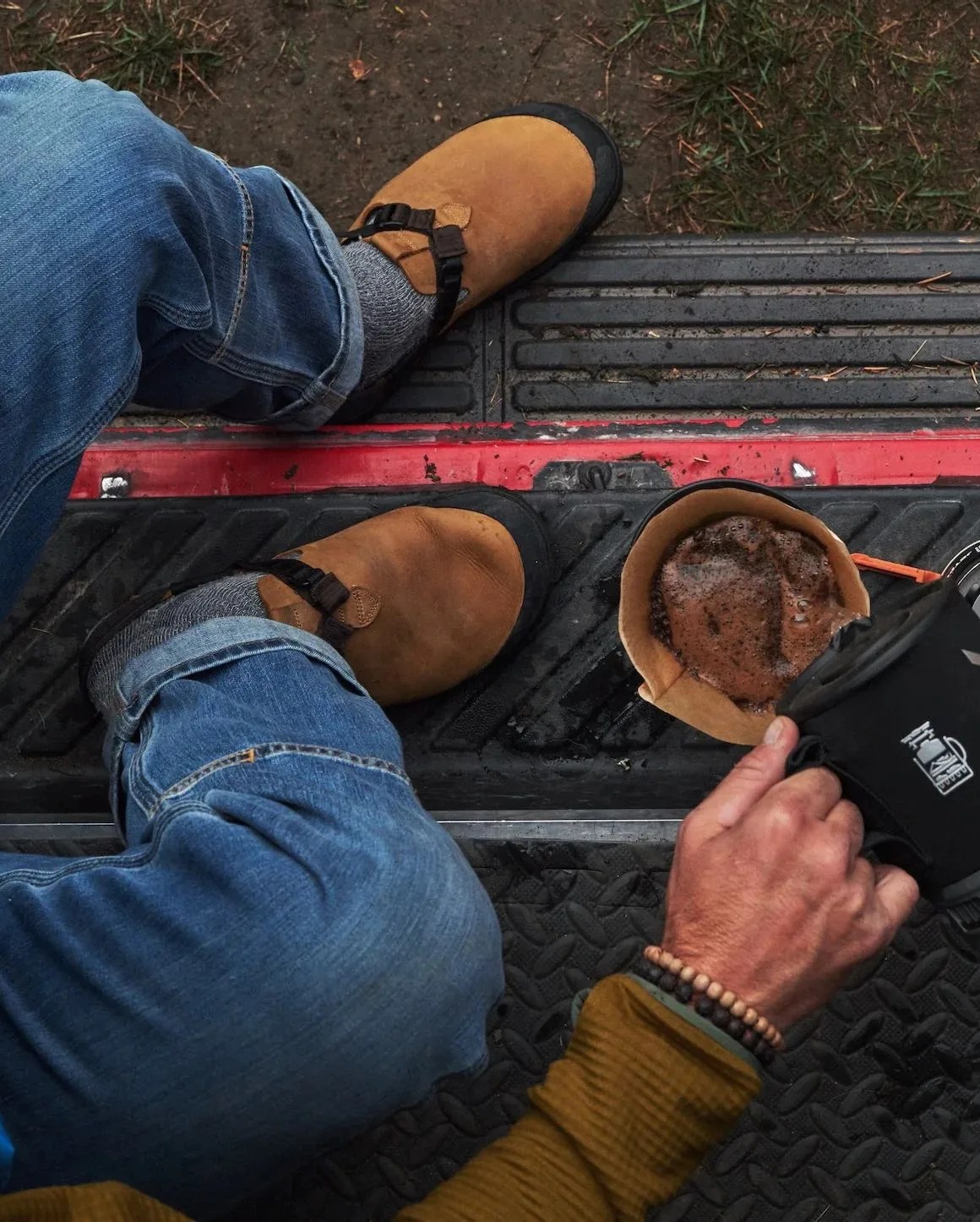 man pouring coffee while wearing bedrock sandals leather mountain clog