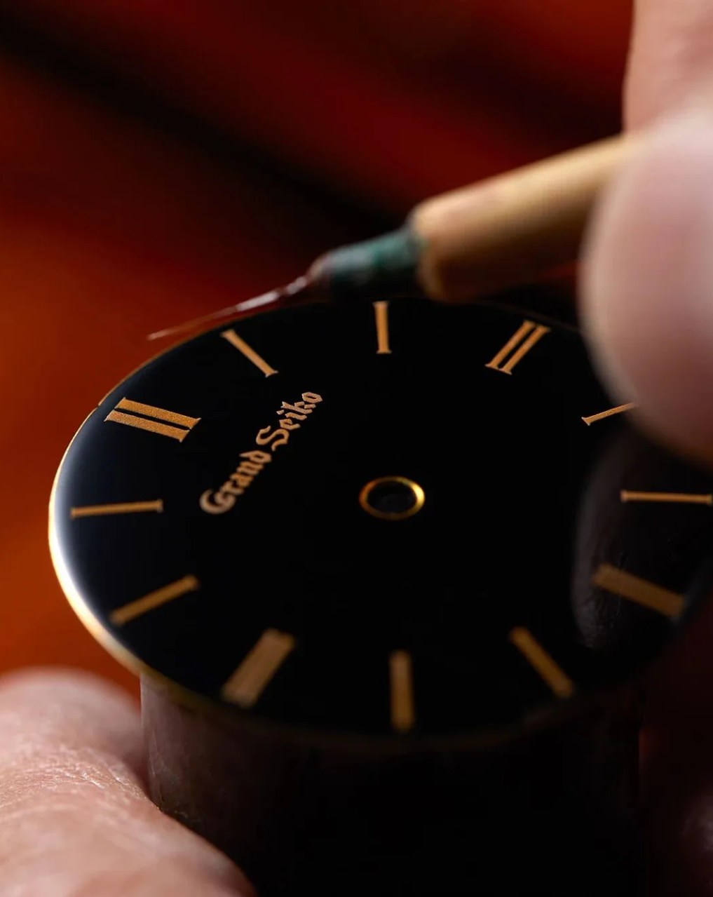 person painting on the dial face of grand seiko sbgw295 watch