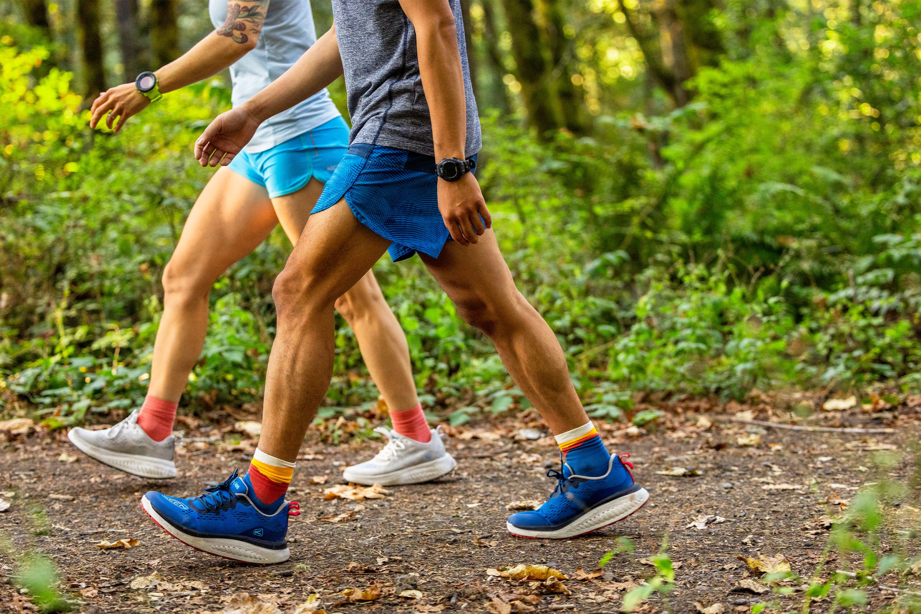 two people walking on a wooded trail