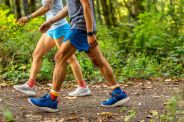 two people walking on a wooded trail