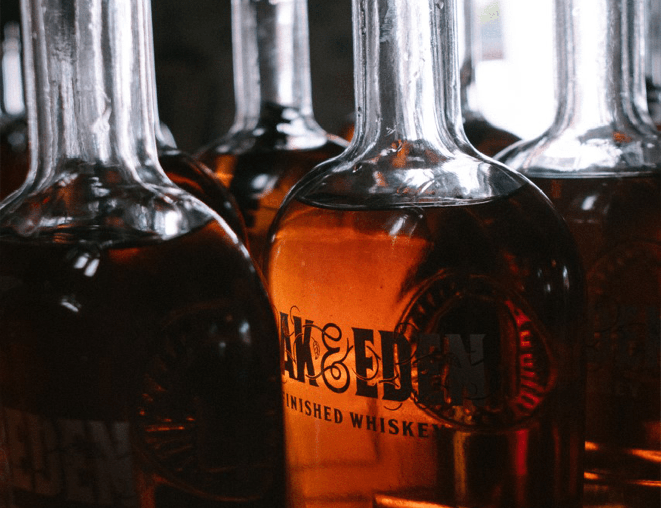 glass bottles being filled with oak and eden whiskey