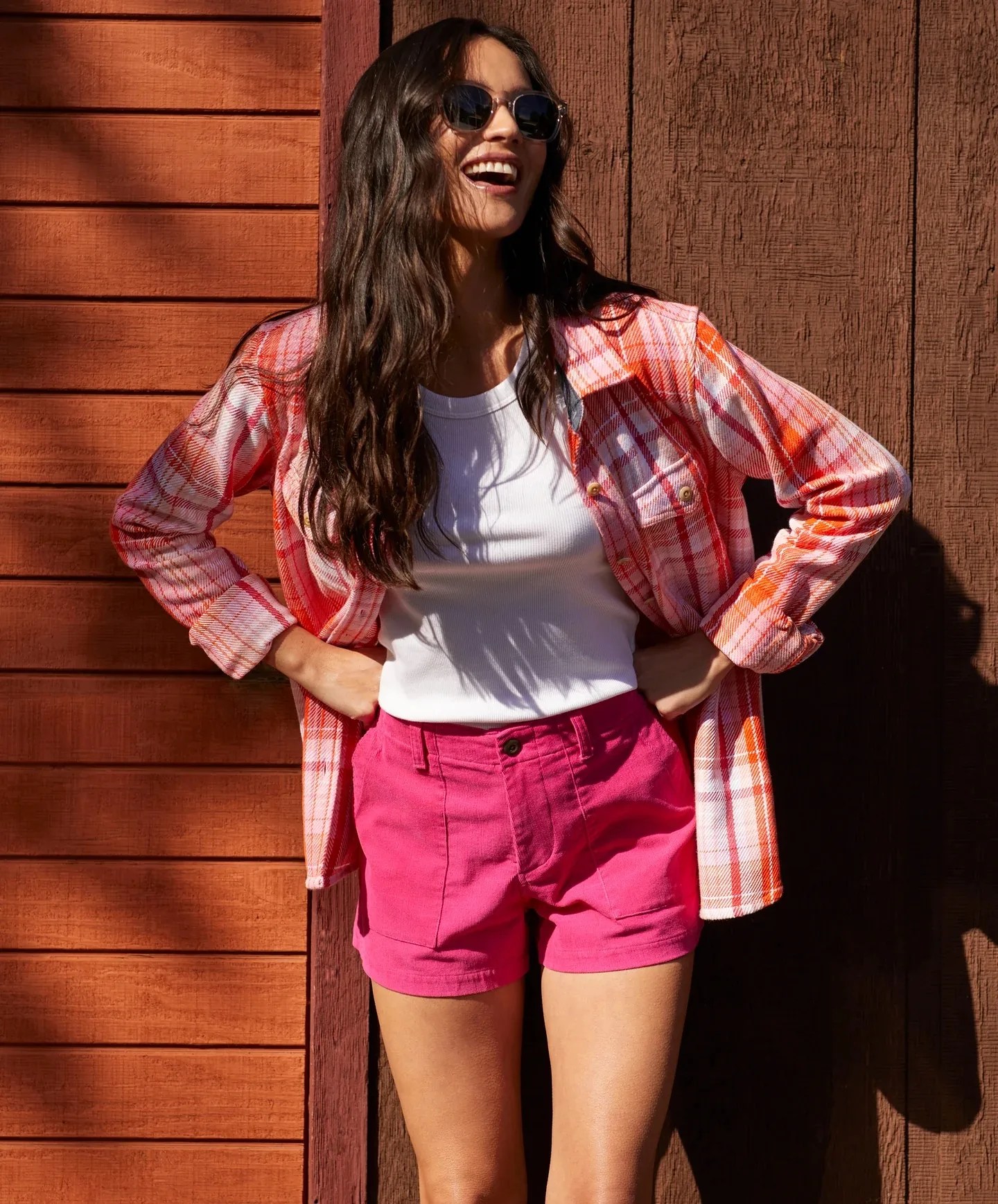 smiling woman in a flannel shirt and shorts