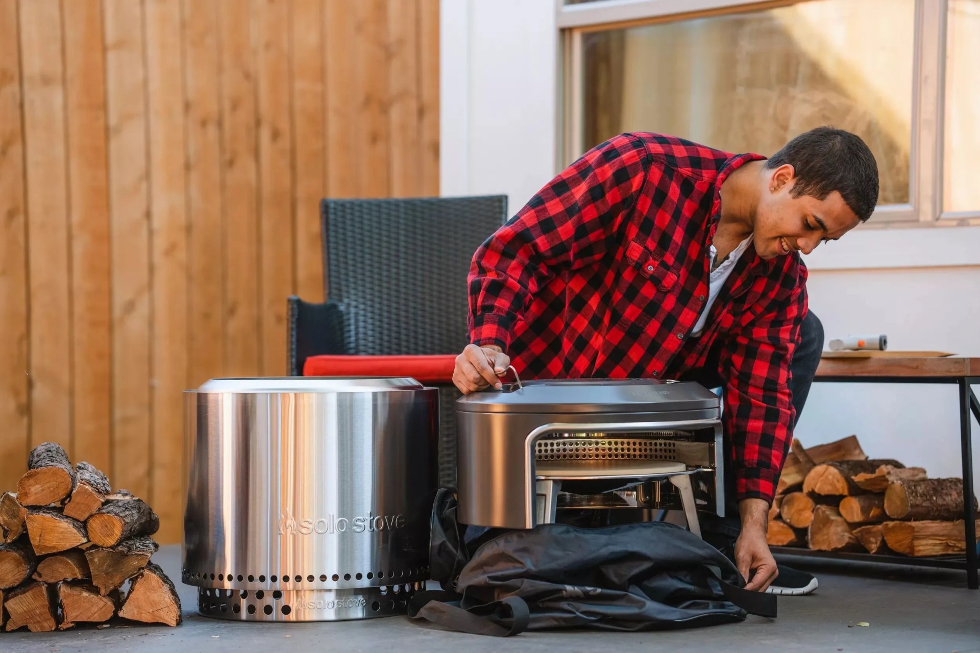 a man using a solo stove pi fire pizza oven