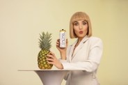 chloe fineman holding a can of nutrl vodka seltzer next to a pineapple on a table