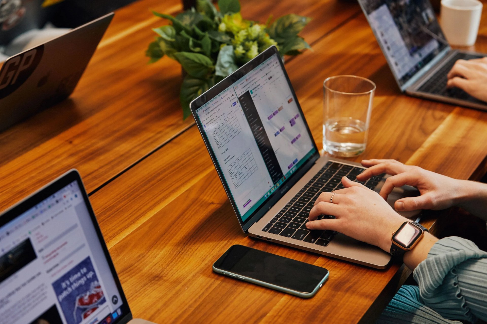 group of laptops, open, on a wooden table