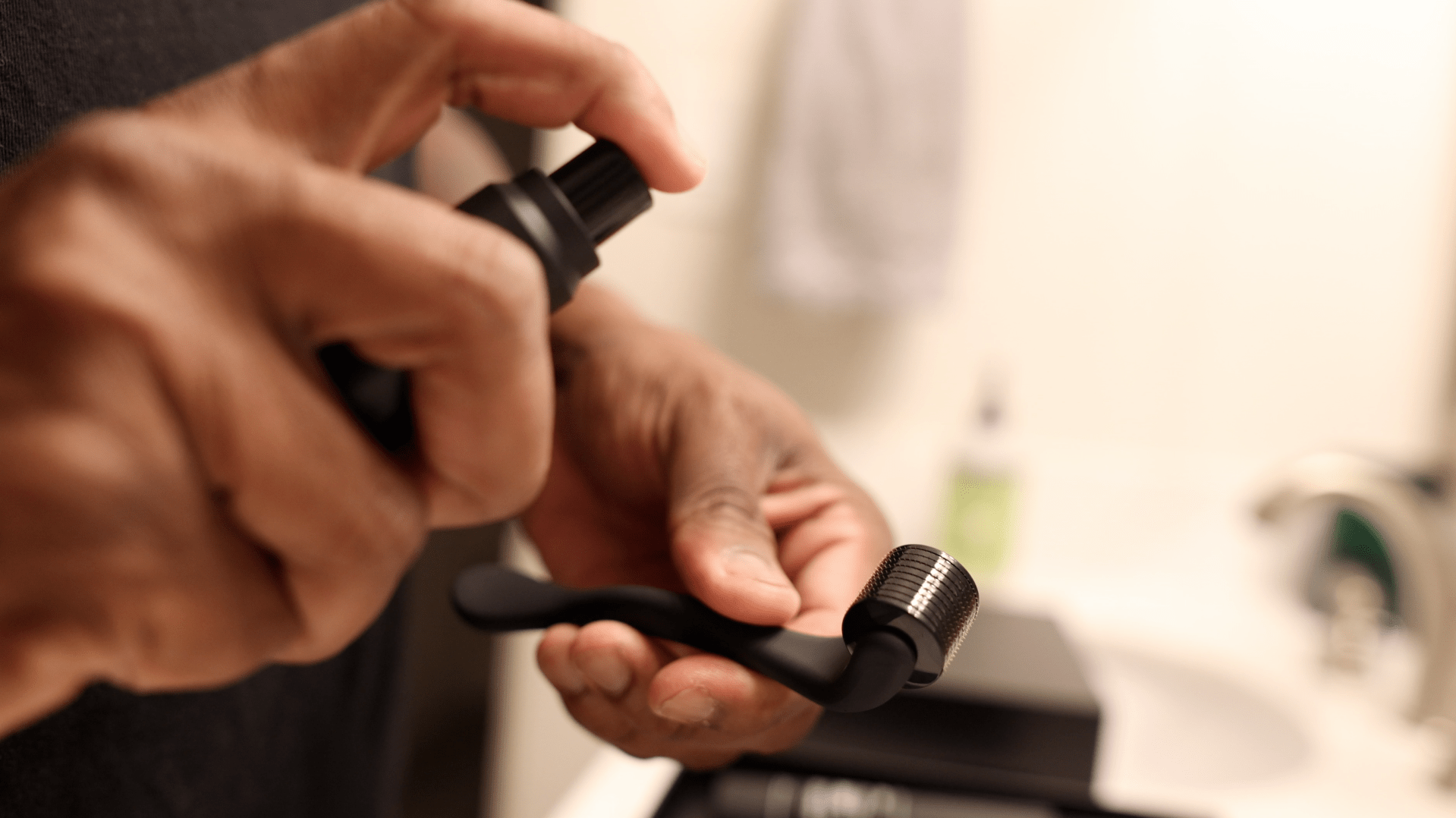 a person spraying sanitizer on a face roller in a bathroom