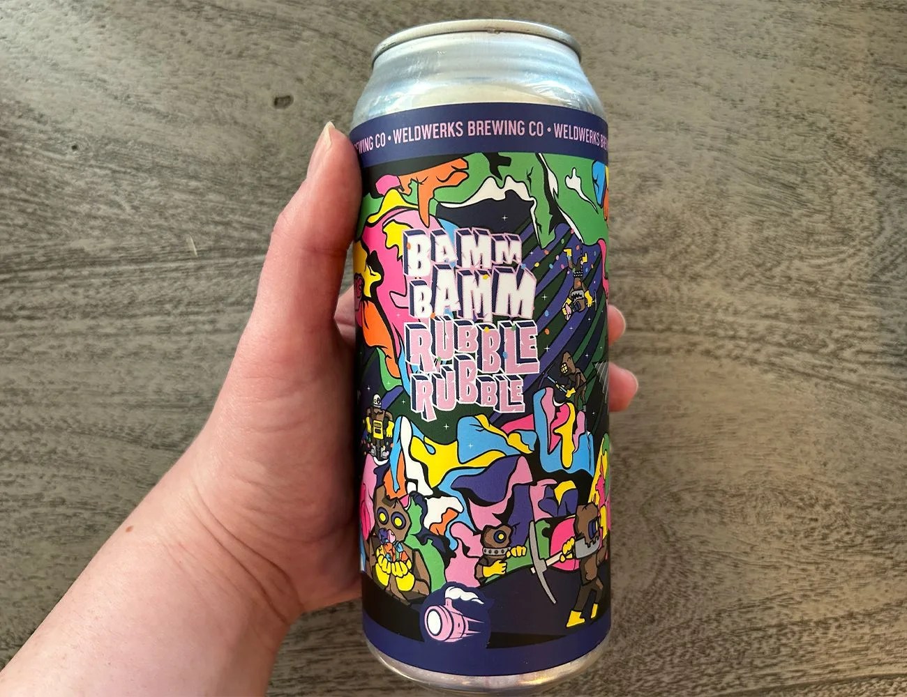 a hand holding a beer can