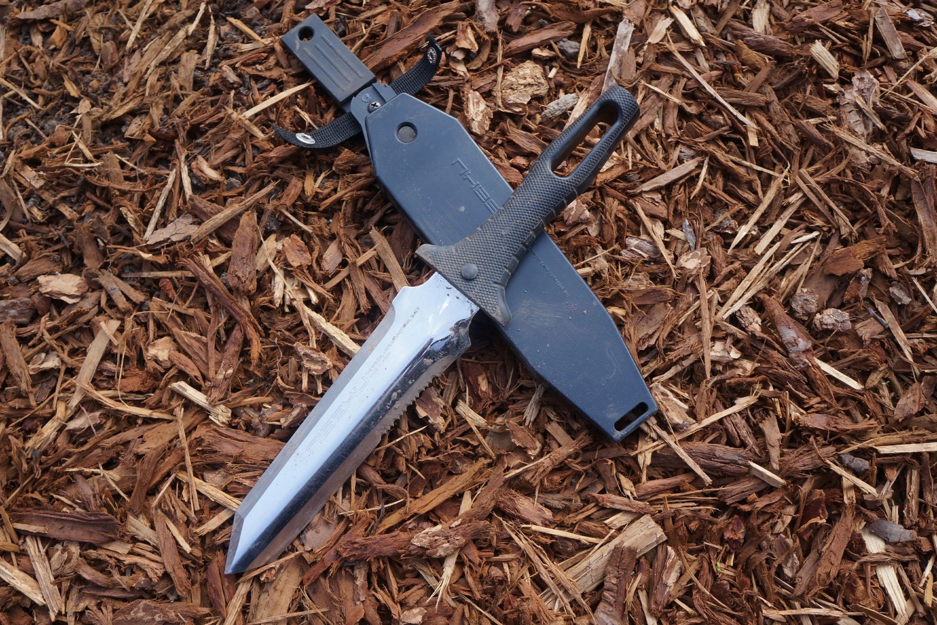 a garden knife and sheath on mulchy ground
