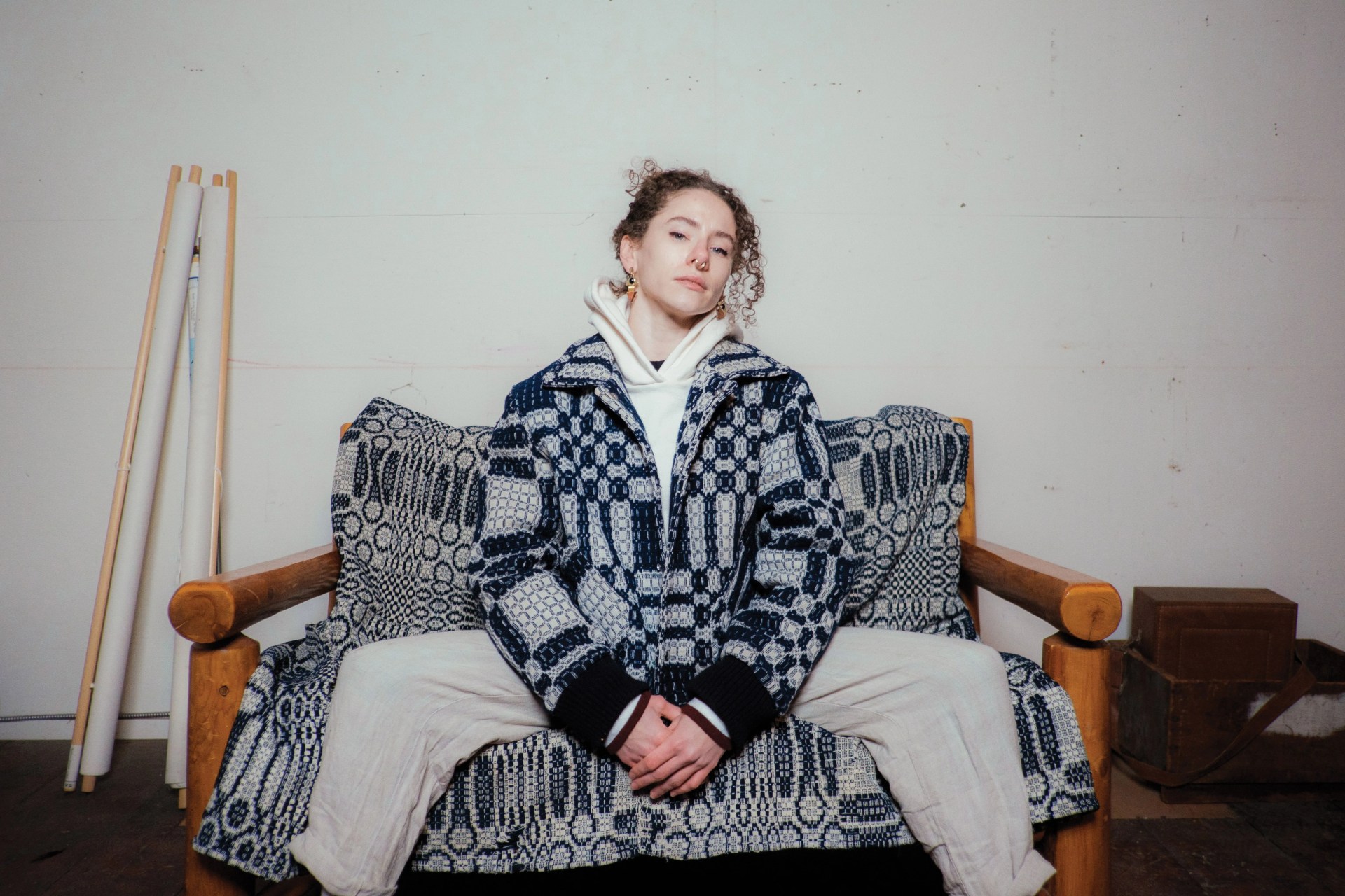 a person sitting on a couch wearing a slow process jacket