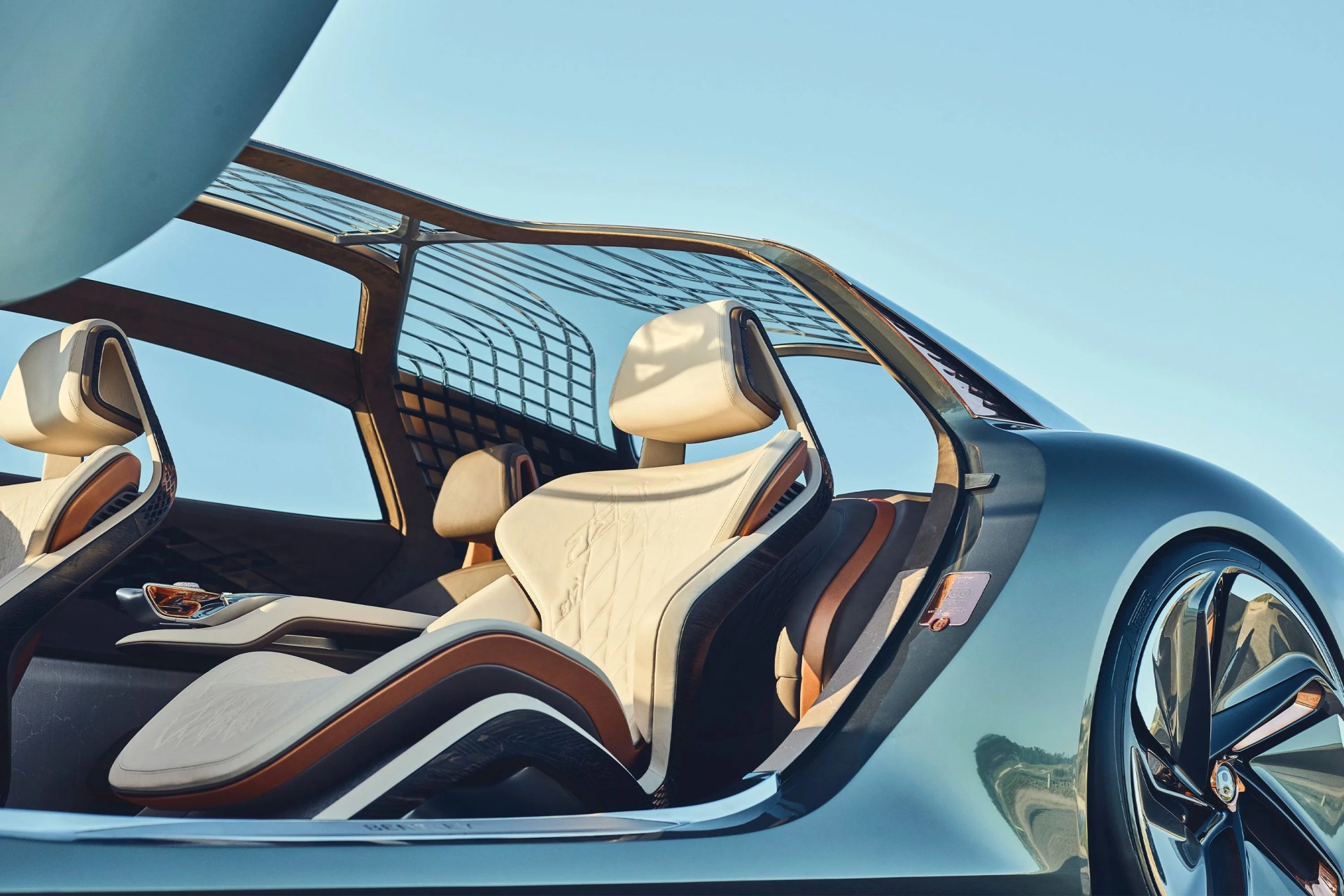 a bentley car with the driver side door open peering into the two front seats