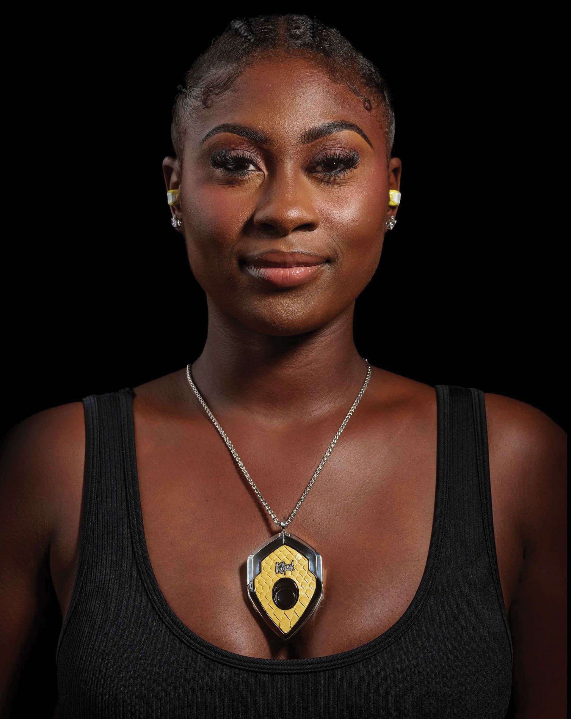 a woman wearing klipsch ear buds with the case as a necklace pendant