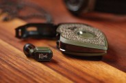 klipsch ear bud with case on a wood table