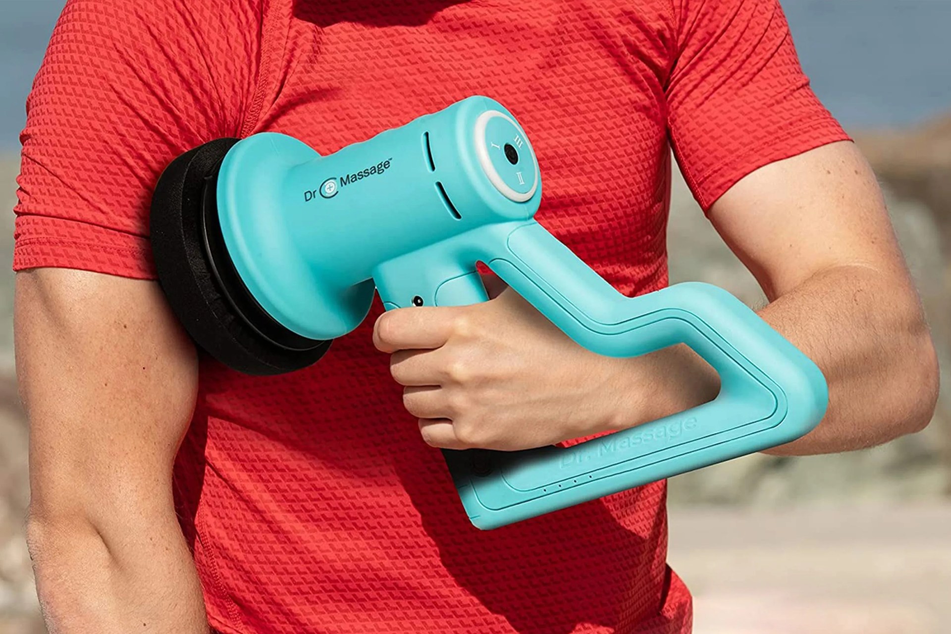 a man using a massage gun on his arm