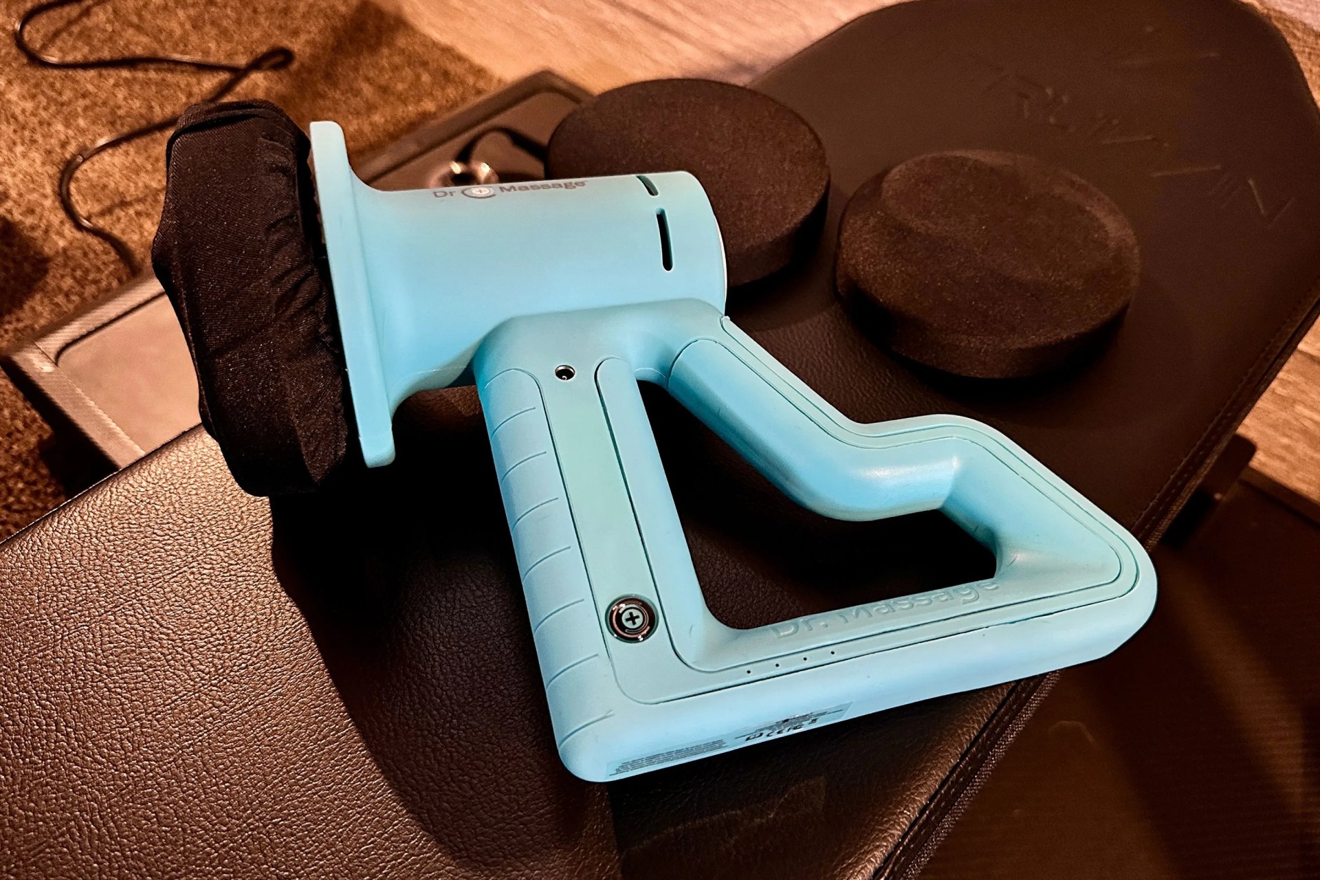 dr massage prowlr orbital massage gun on a weightlifting bench with additional gun heads