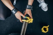 female putting safety lock on barbell in gym