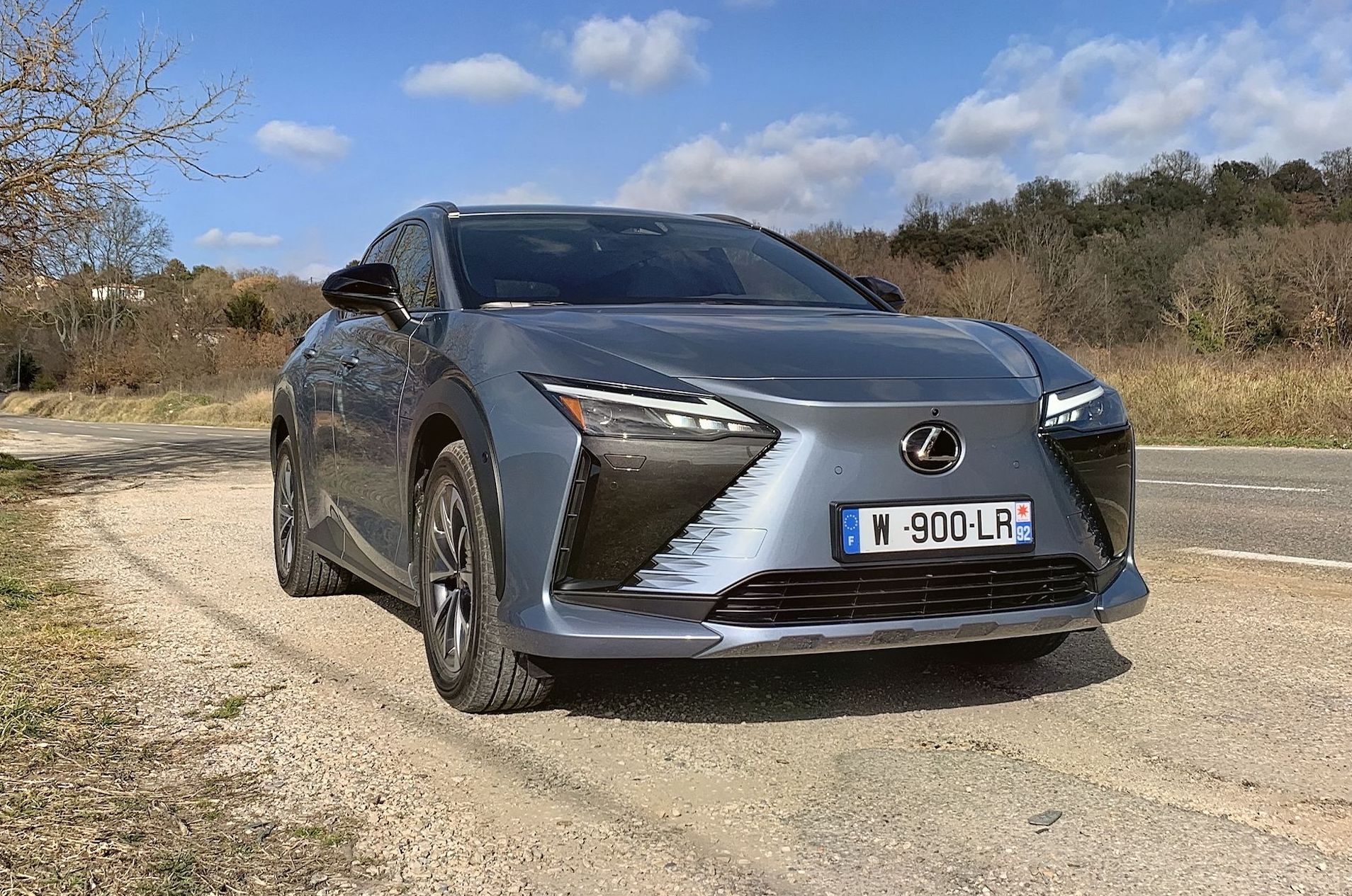 lexus rz parked by the side of a rural road