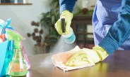 a man wipes down the table's surface, house chores