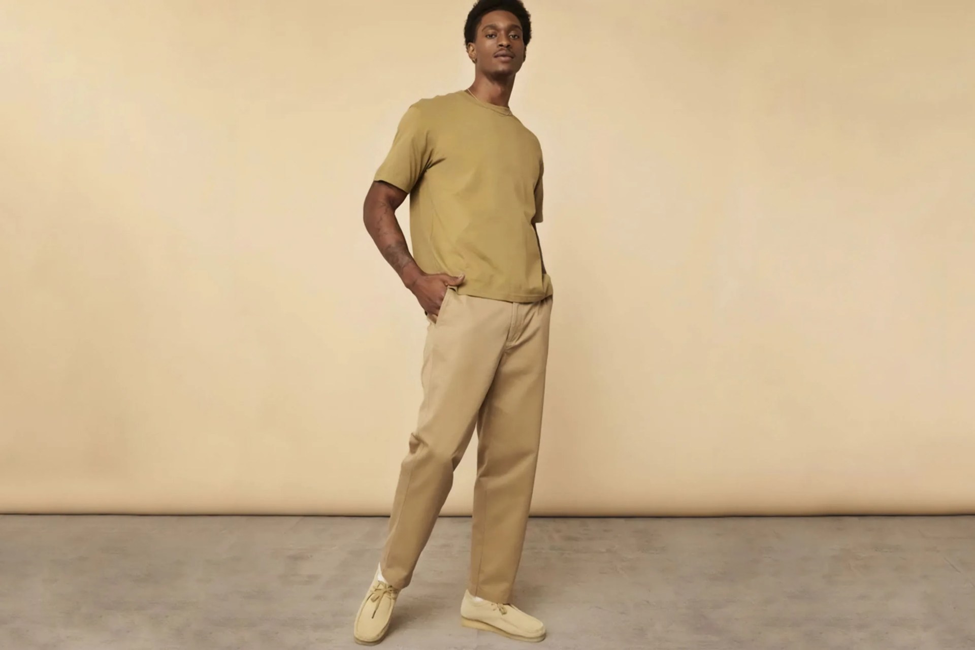 a man wearing khaki chinos and a tan tshirt