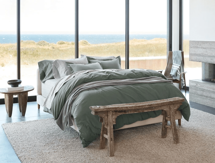 bed in front of windows showing beach