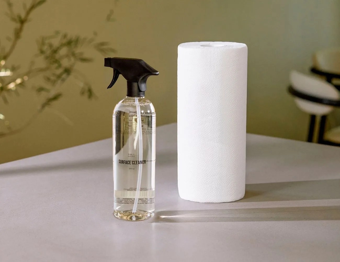 a spray bottle and paper towel roll on a counter