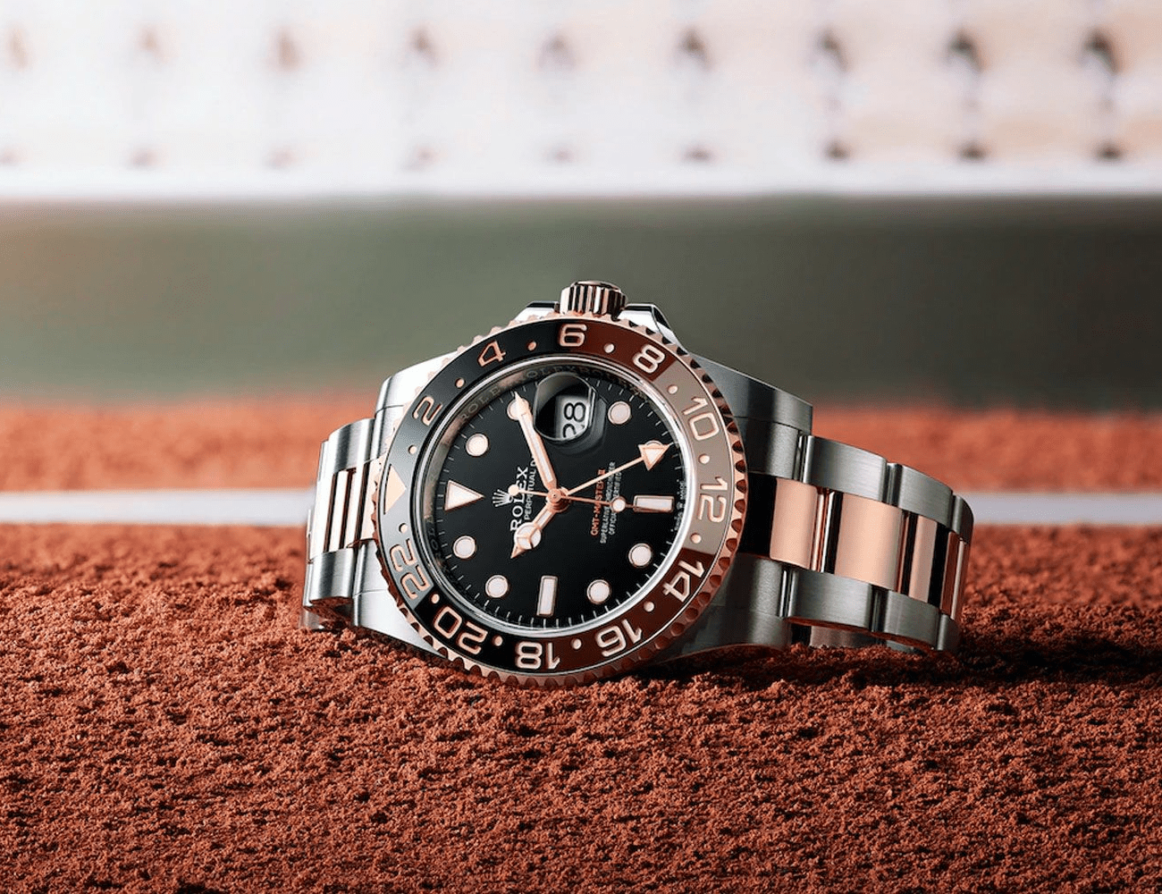 a silver rolex gmt on a baseball diamond