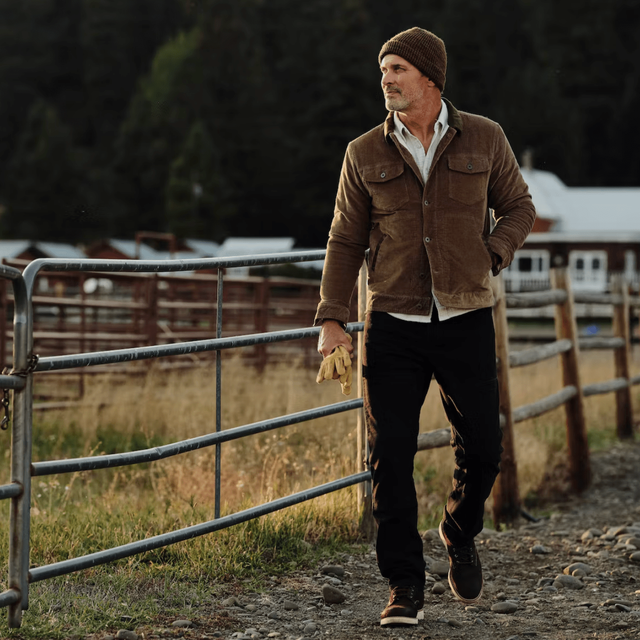 person walking along fence in corduroy trucker jacket