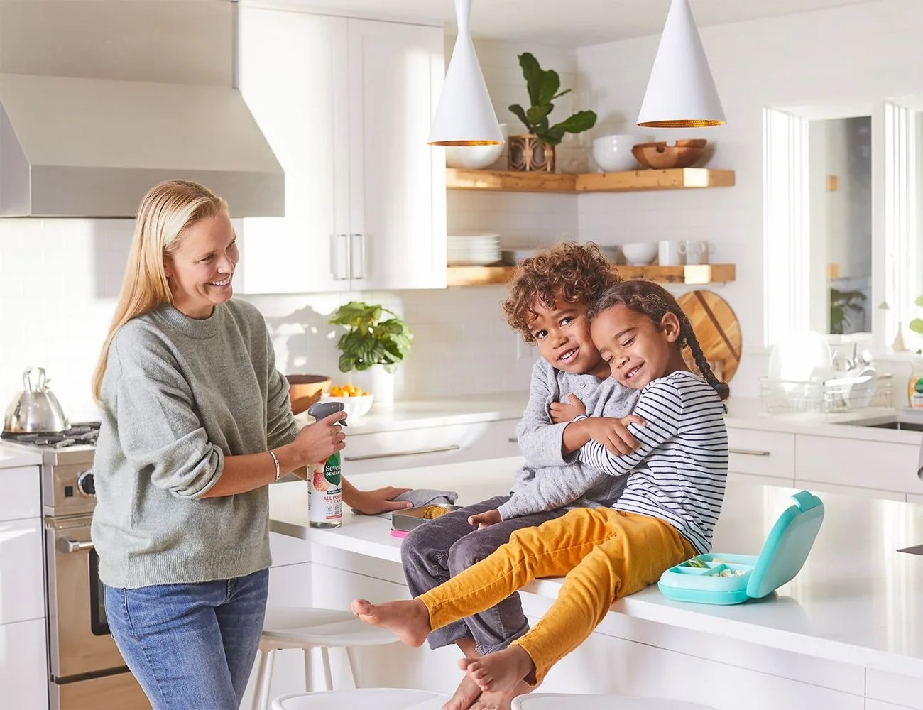 a woman with 2 kids in a kitchen
