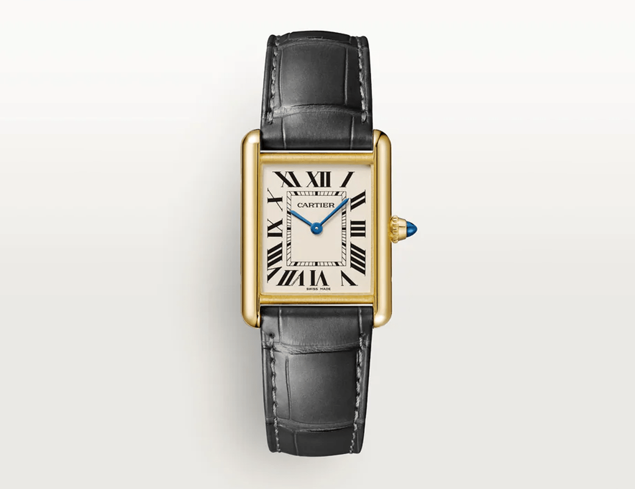 a rectangle shaped watch with brown leather strap and gold dial