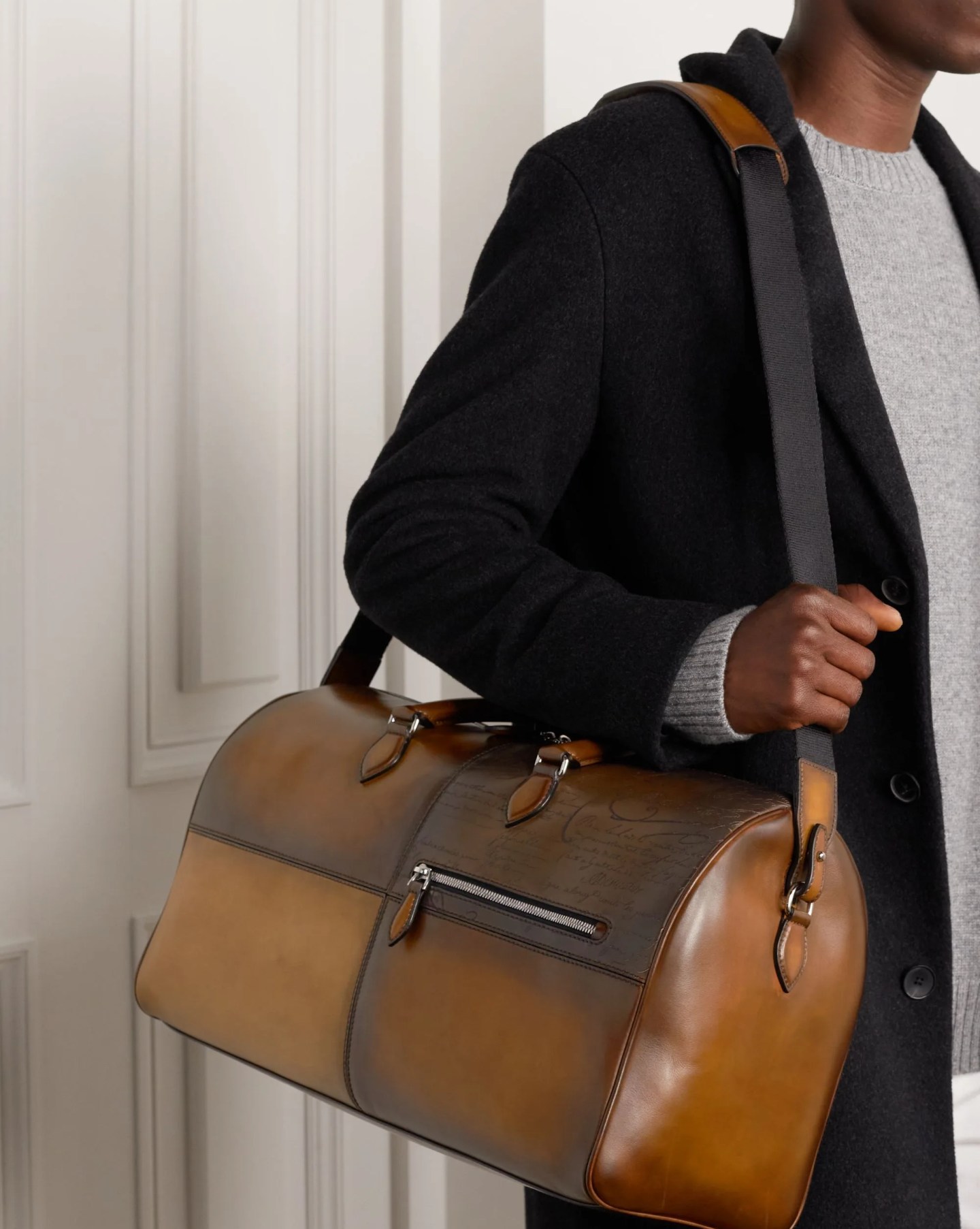 man carrying berluti scritto panelled venezia leather weekend bag