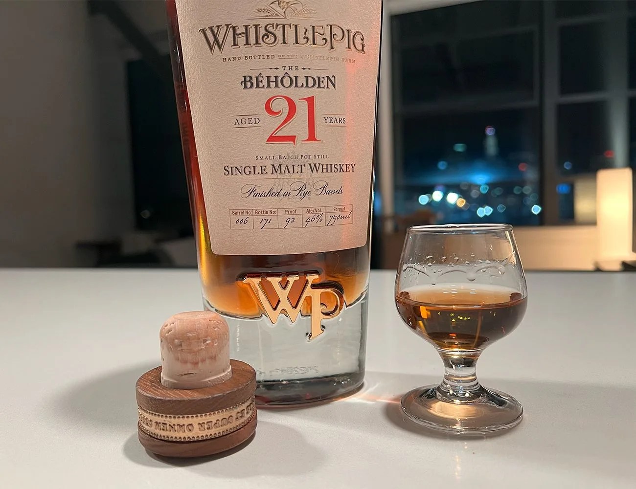 a whiskey pig whiskey bottle on a counter with a tasting glass