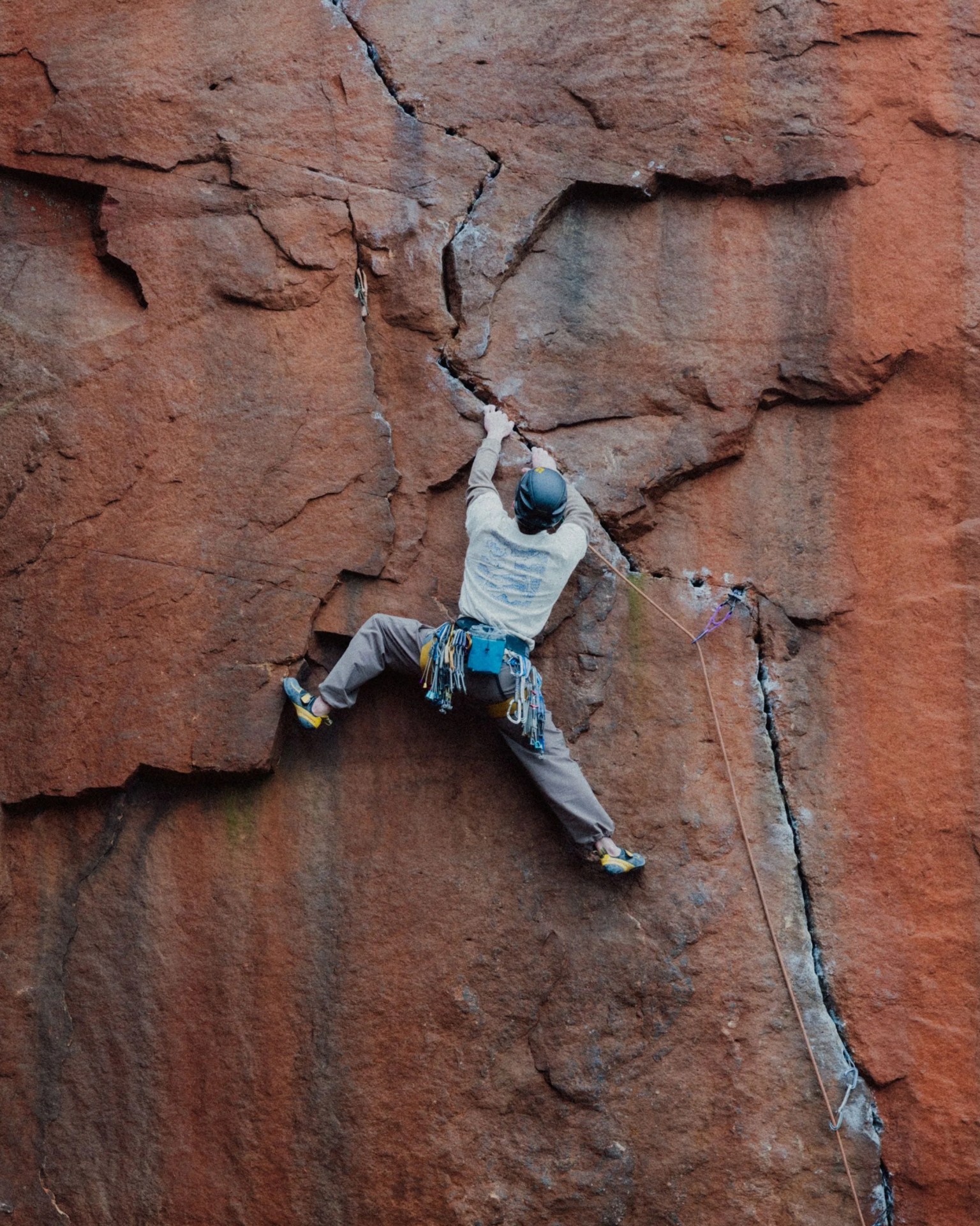man climbing stone wall edge