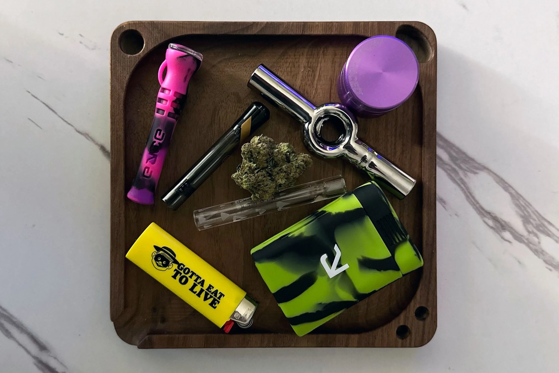 chillums and one hitters on a wooden tray with a lighter, grinder, and weed nugget