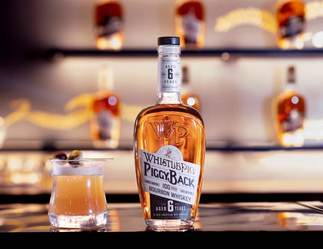 a bottle of bourbon on a table next to a glass