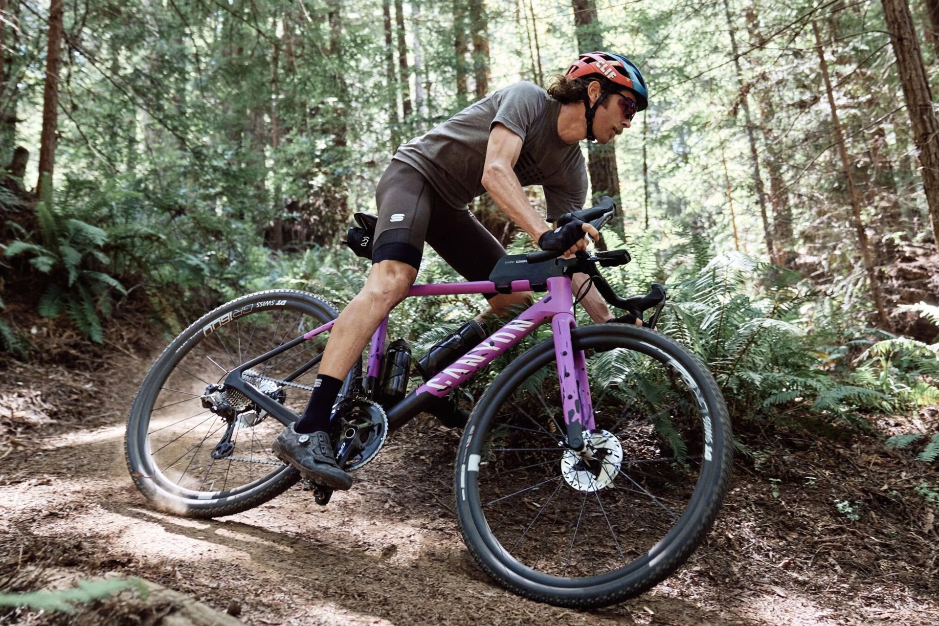man riding a canyon bike through the woods
