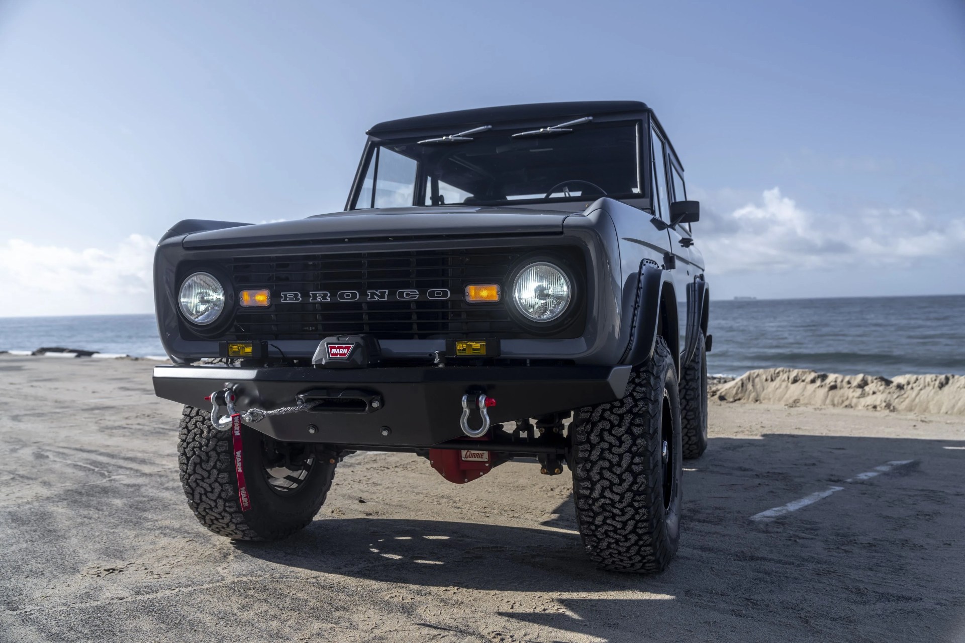 vintage bronco in a beach parking lot