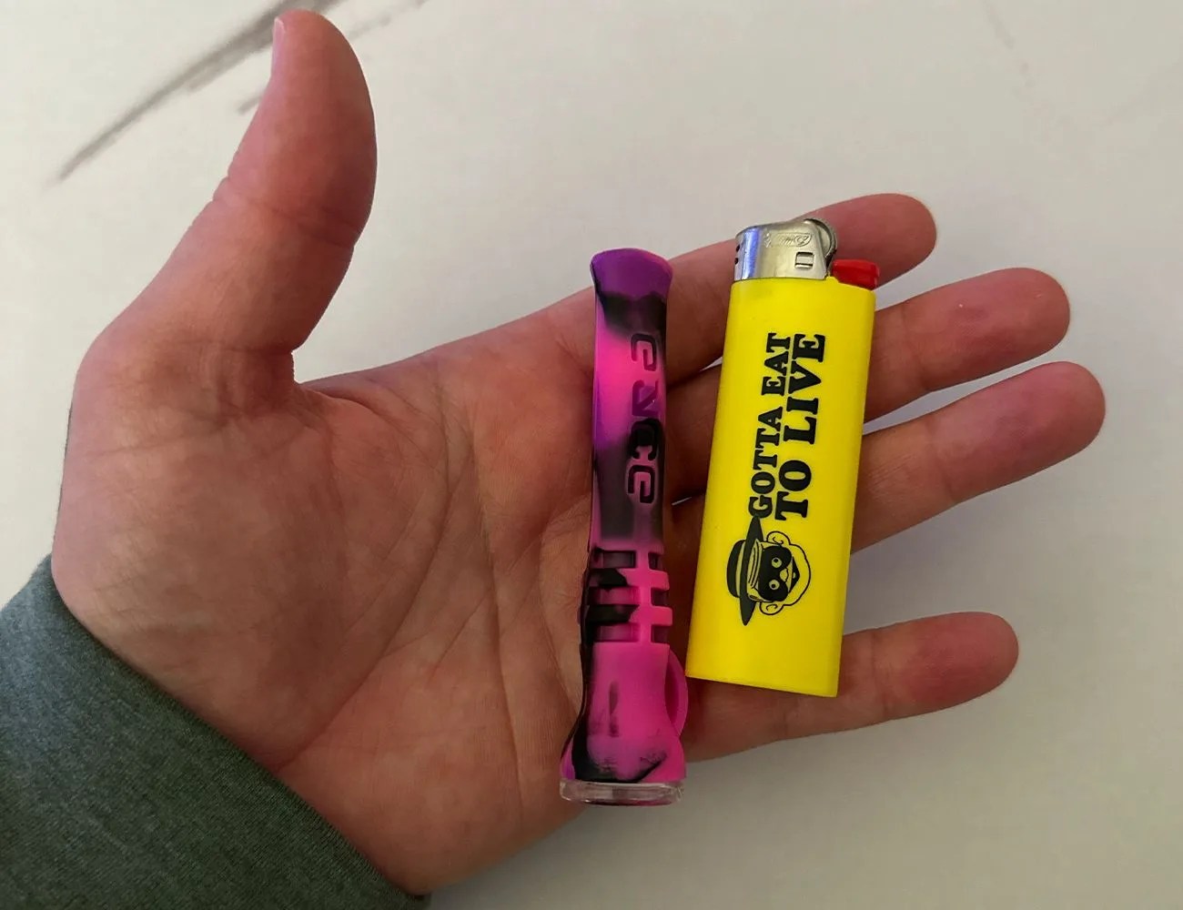 a chillum in a hand with a lighter