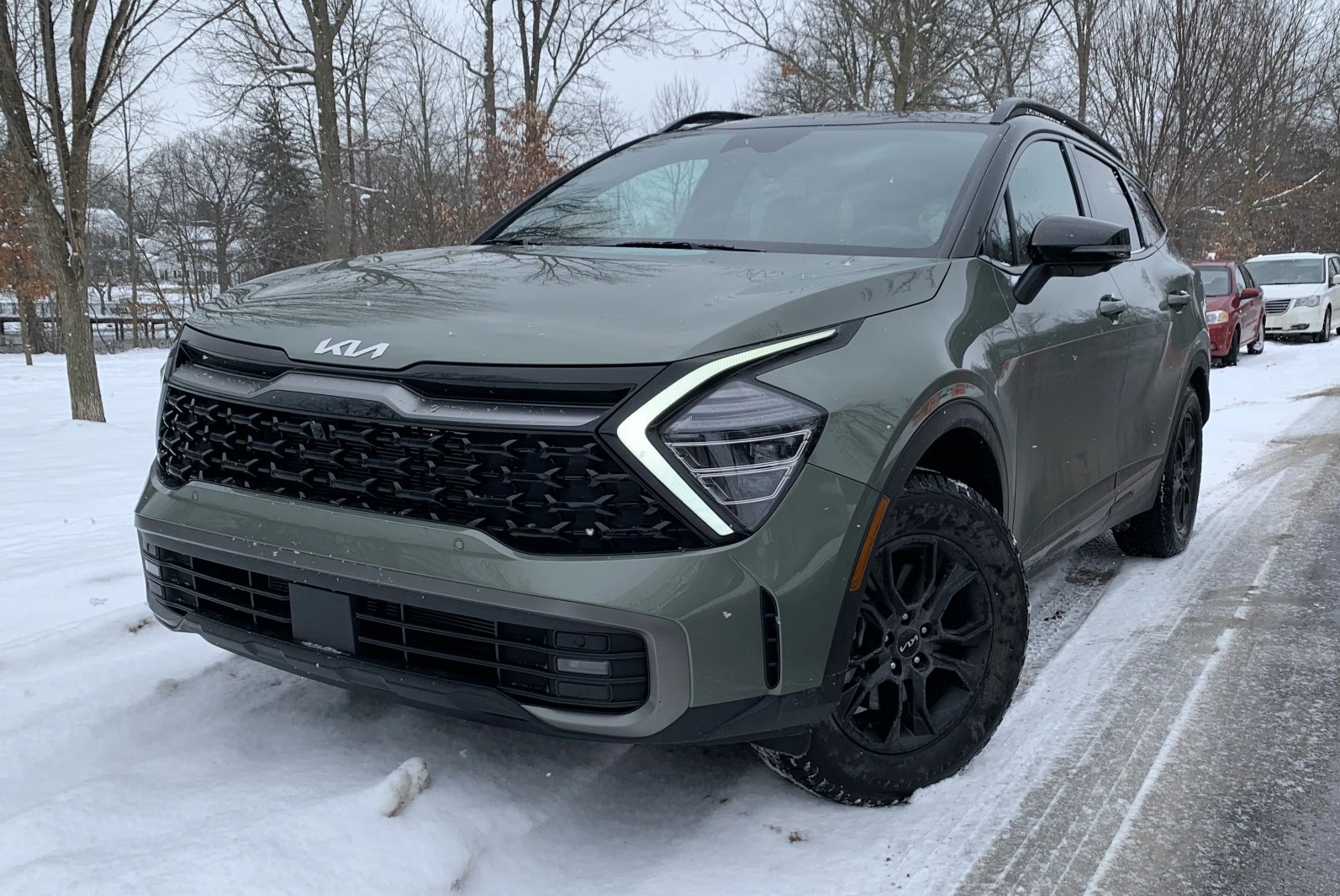 kia sportage front quarter angle next to snowy park