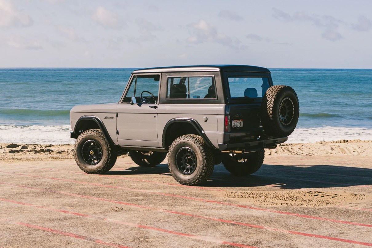 vintage bronco in a beach parking lot