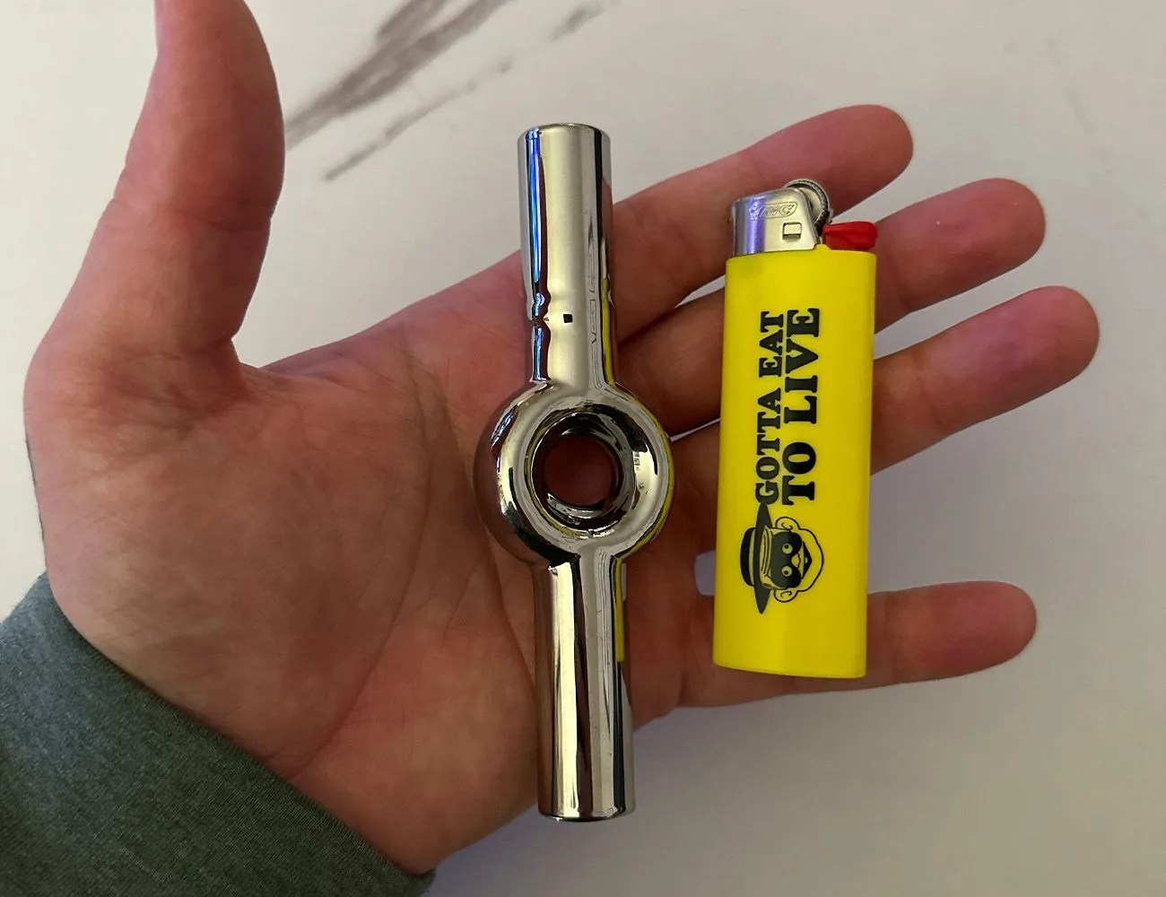 a chillum in a hand with a lighter