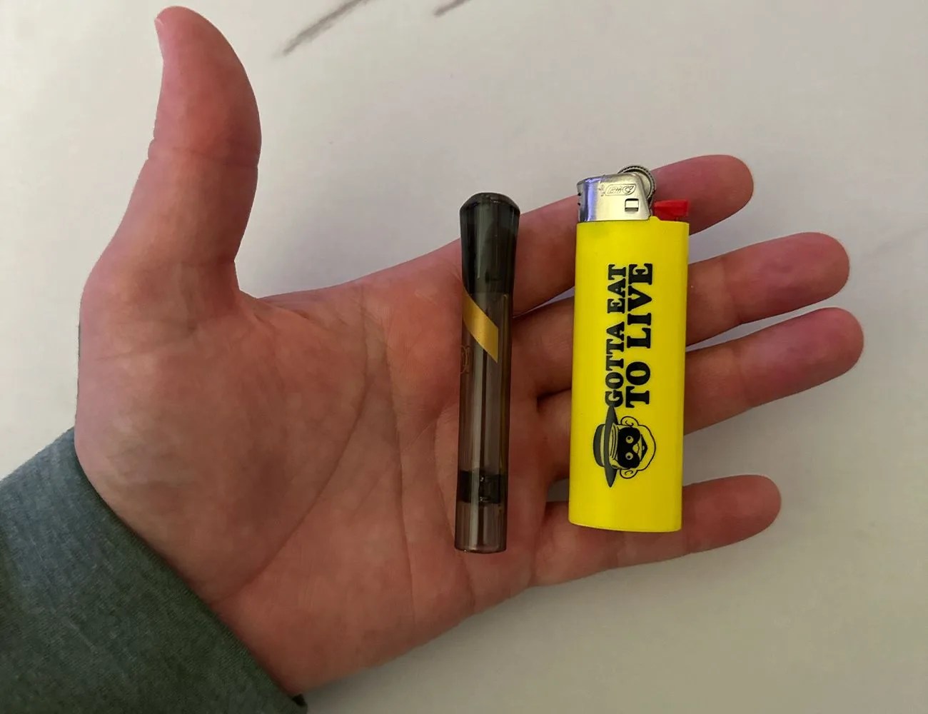 a chillum in a hand with a lighter