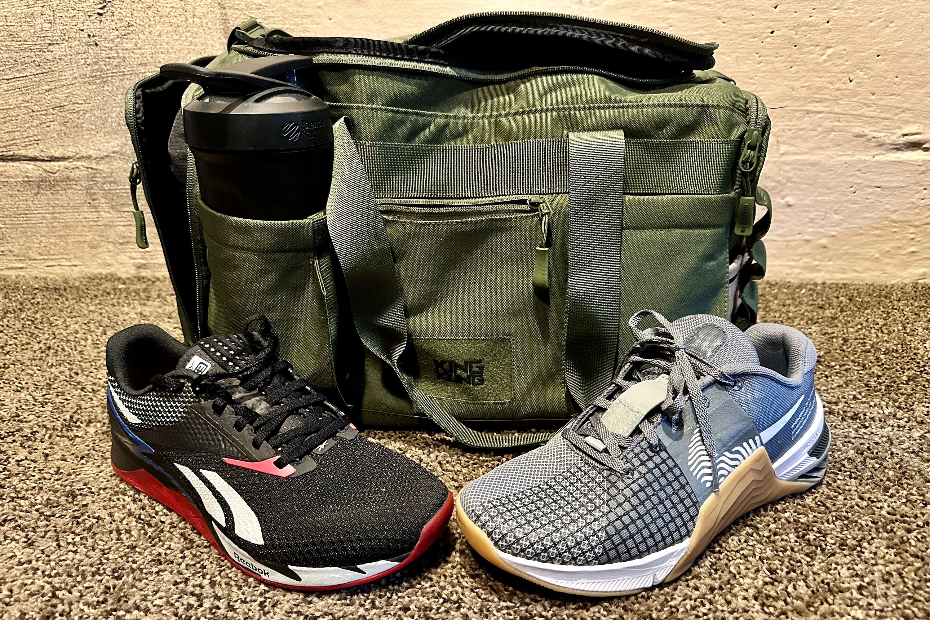 two sneakers on a carpet in front of a gym bag