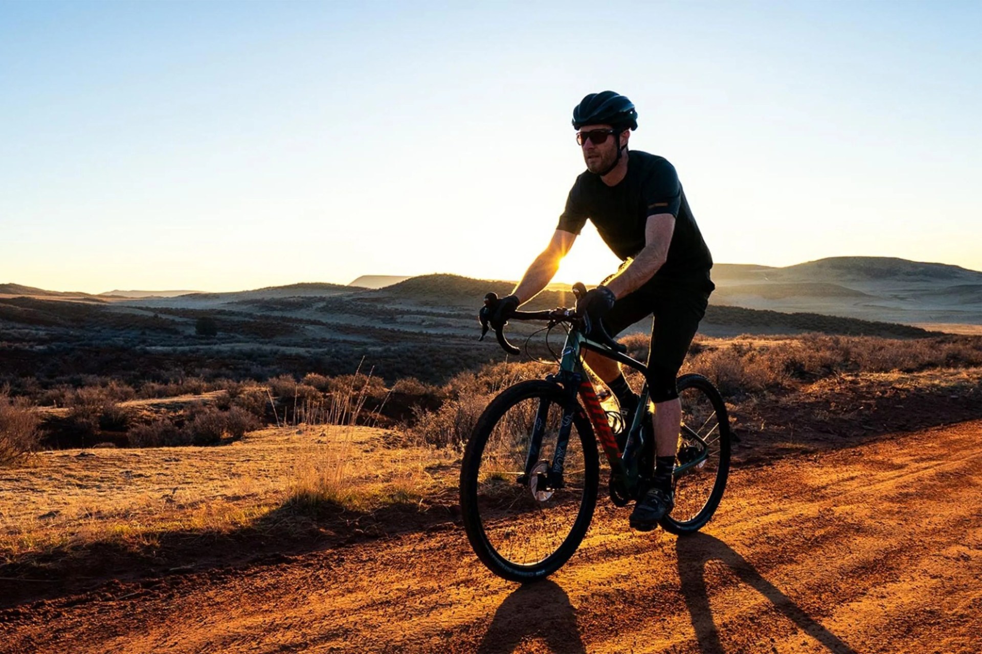 man riding a bike on a dirt road