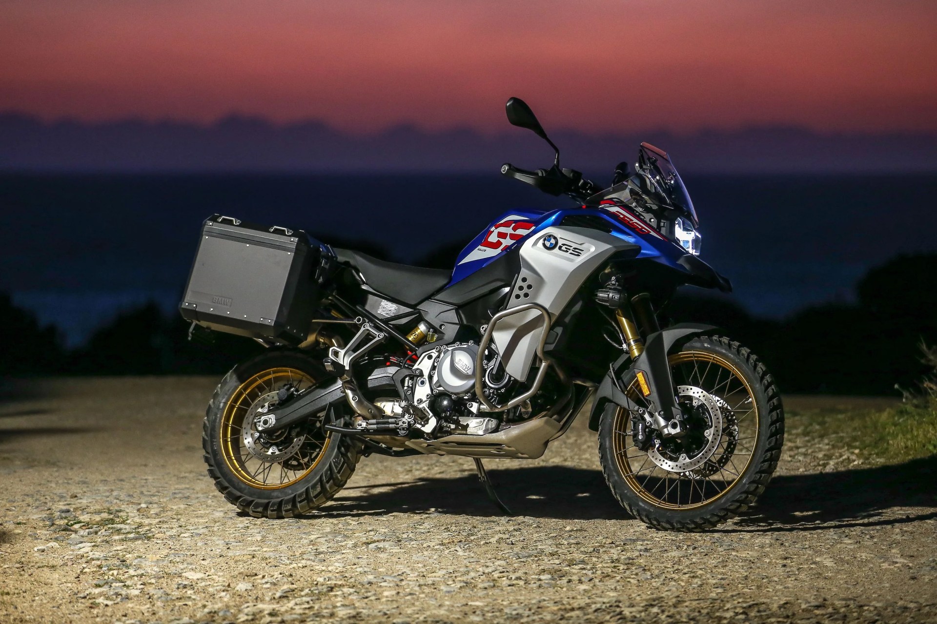 bmw f 850 gs parked in dirt with a sunset in the background