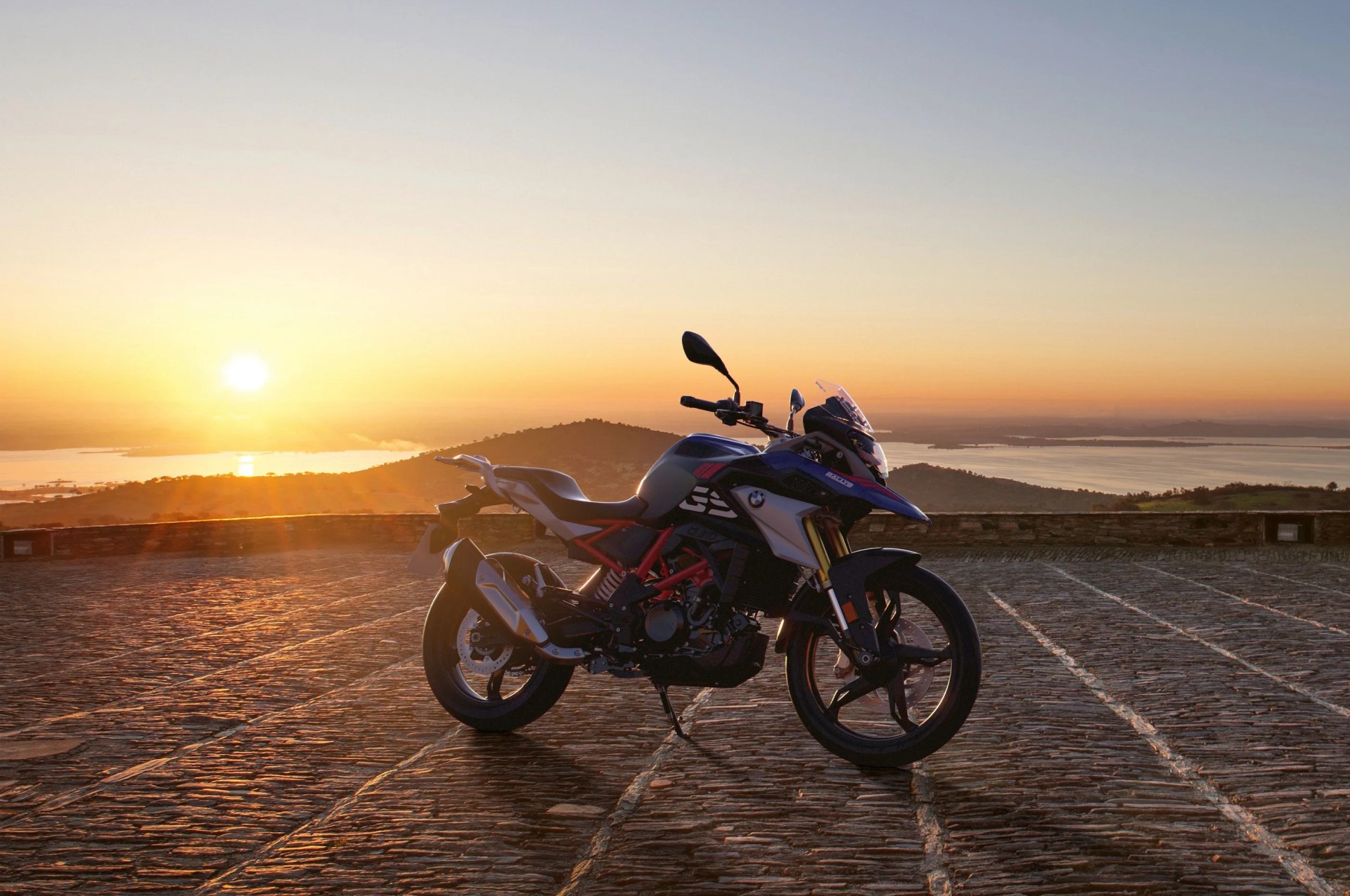 bmw motorcycle parked on a terrace with an ocean sunset in the background