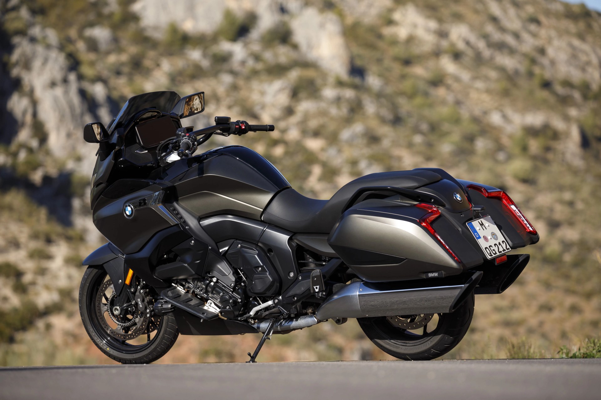 bmw k 1600 b motorcycle parked on tarmac in front of a mountain